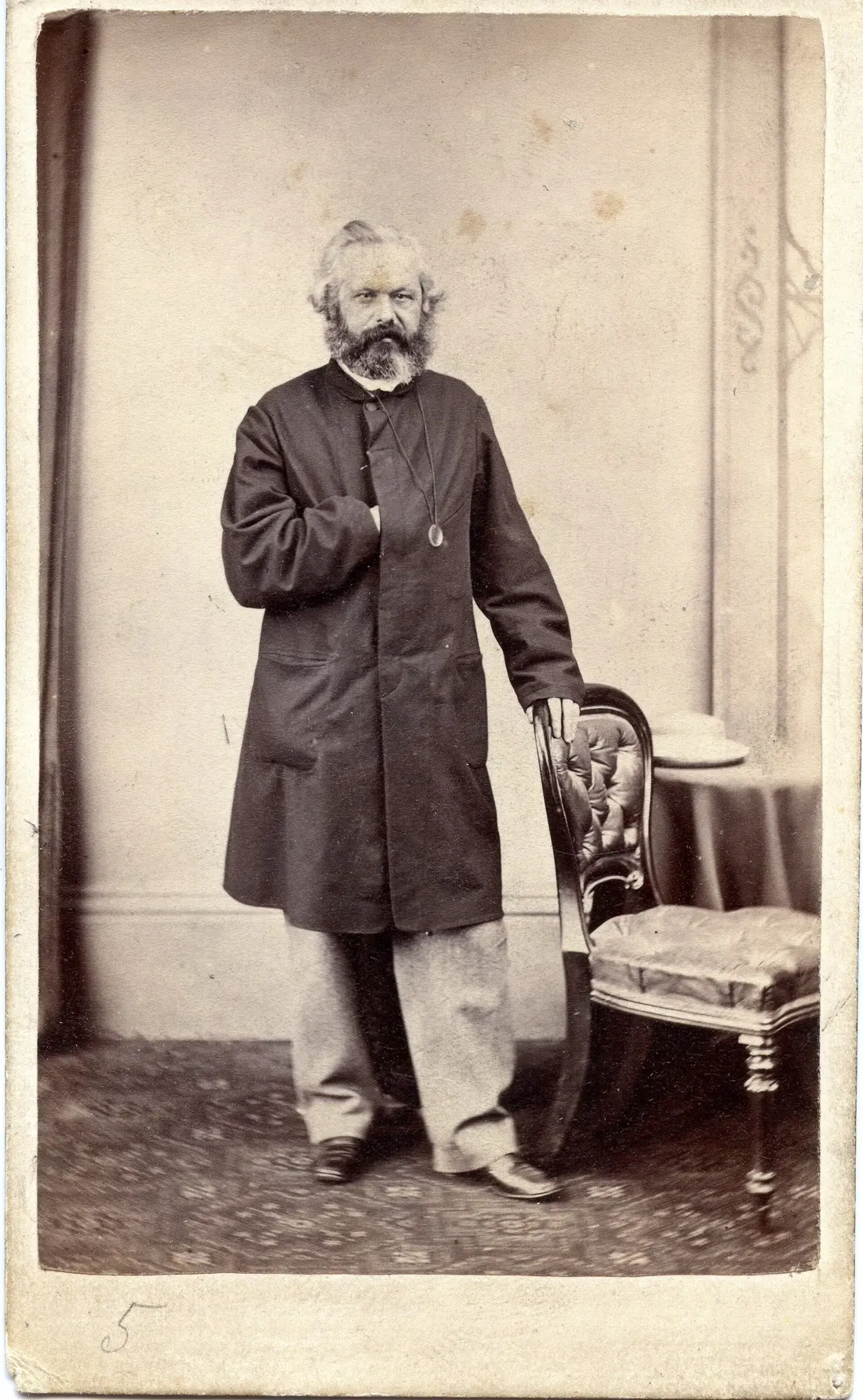 Karl Marx à Margate en mars 1866, debout, en redingote, la main sur un fauteuil.