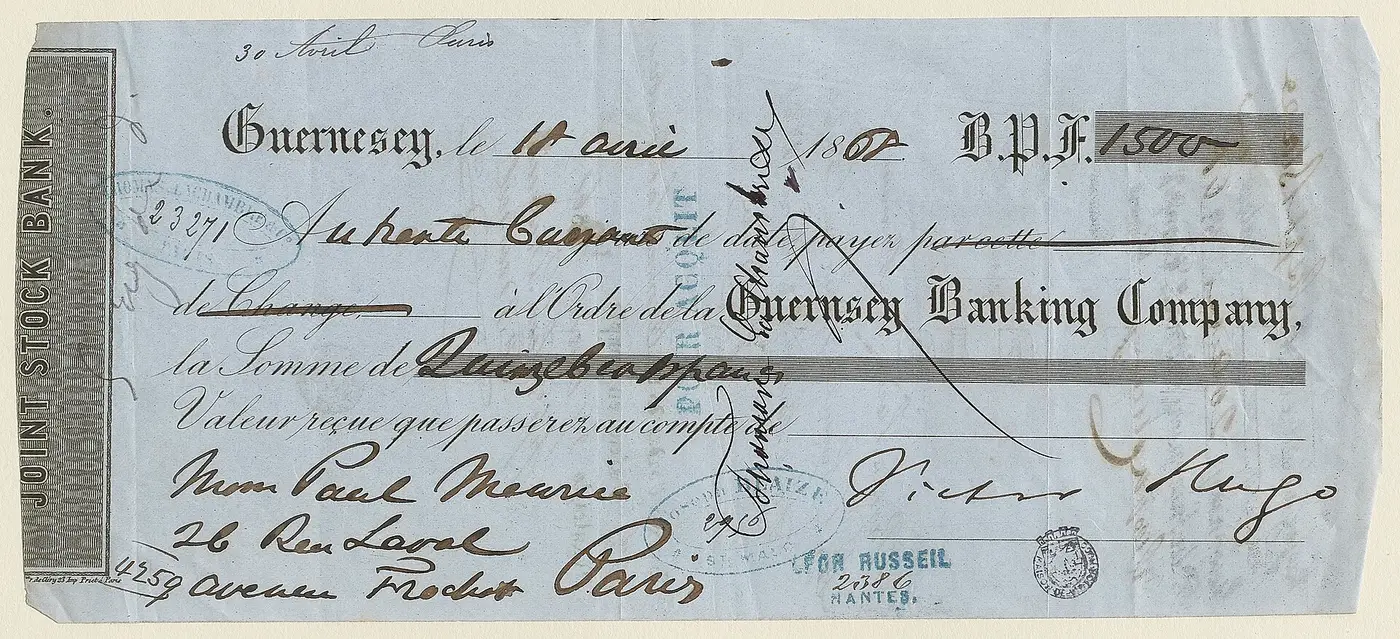 Une lettre de change imprimée sur papier bleu, à l'en-tête de la Guernsey Banking Company, remplie à la main pour quinze cents francs et signée Victor Hugo, couverte de tampons.